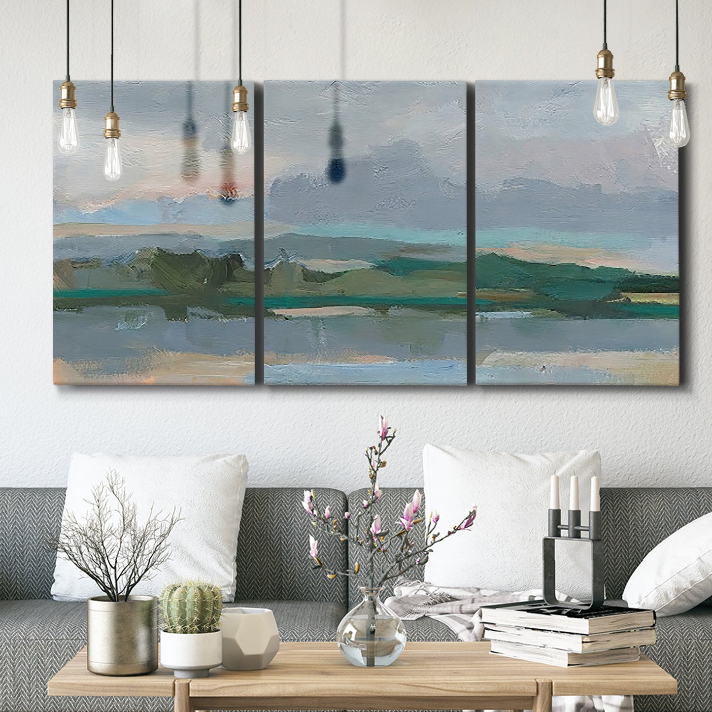 Three-panel canvas wall art featuring twilight landscape with fading light, displayed in a modern living room above seating.