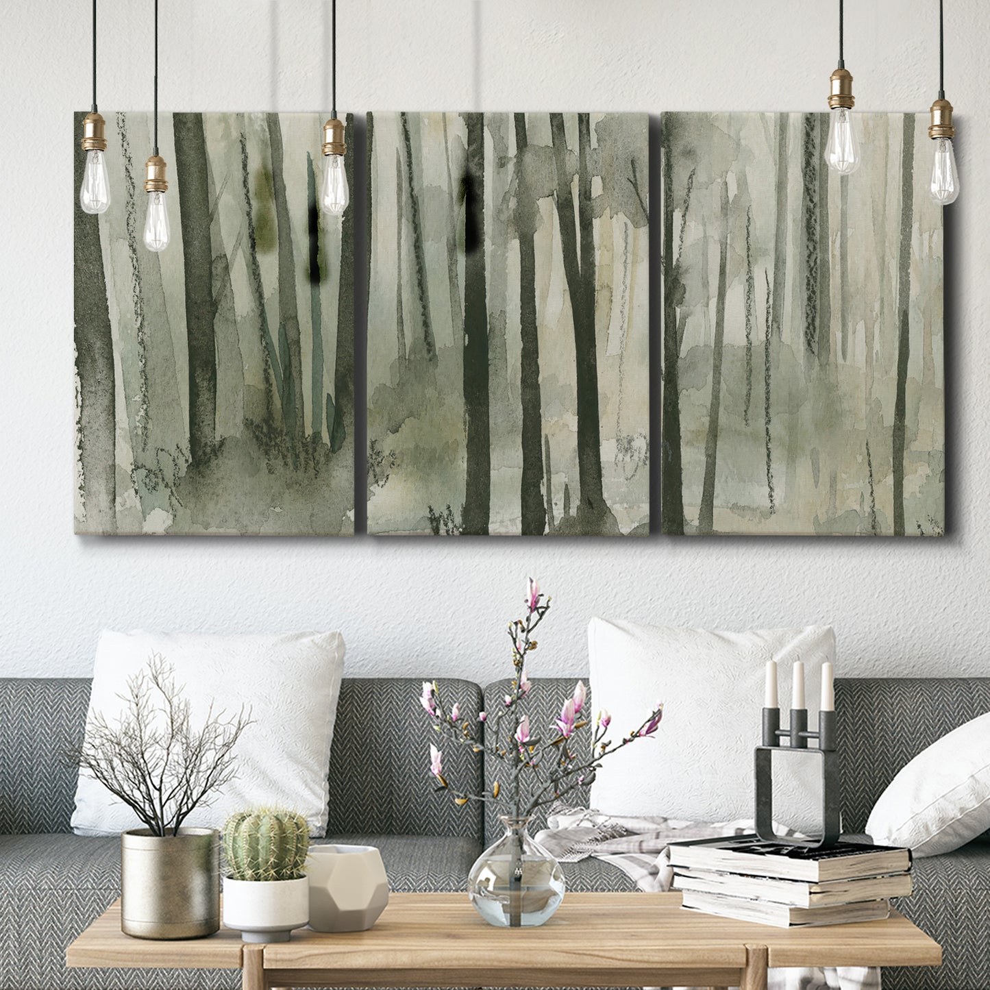 Three-panel canvas wall art featuring wooded forest path watercolor, displayed in a modern living room above seating.