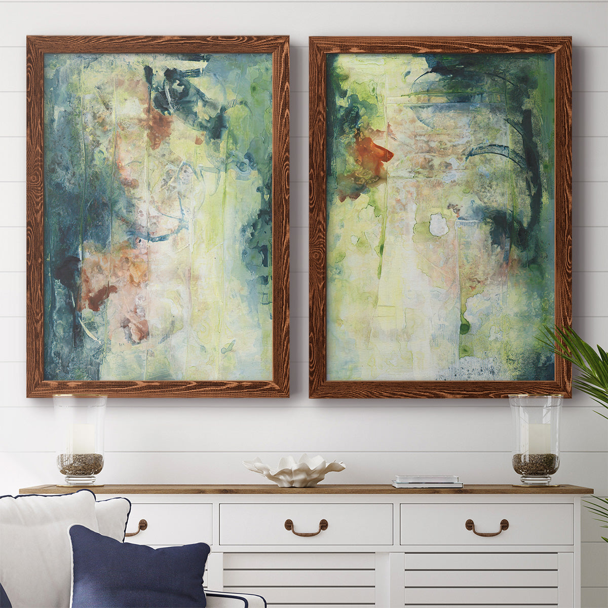 Set of two maple barnwood framed canvas prints depicting a coordinated art pair of layered blue green cream and charcoal textures rendered as nature-inspired mixed-media abstracts above a dining room sideboard.