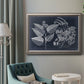 Decorative botanical foliage drawing on navy background in an ornate vintage silver frame displayed in a neutral interior setting.