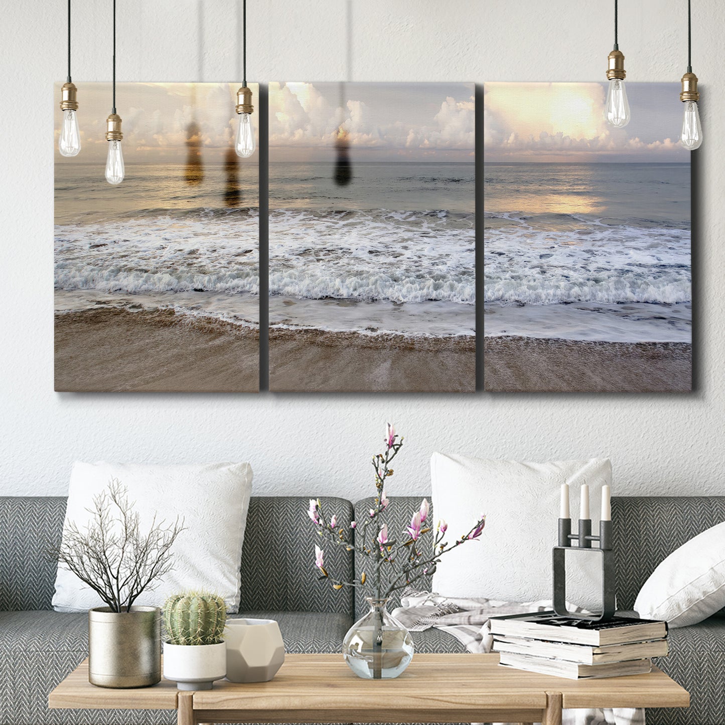 Three-panel canvas wall art featuring calm coastal shoreline seascape, displayed in a modern living room above seating.