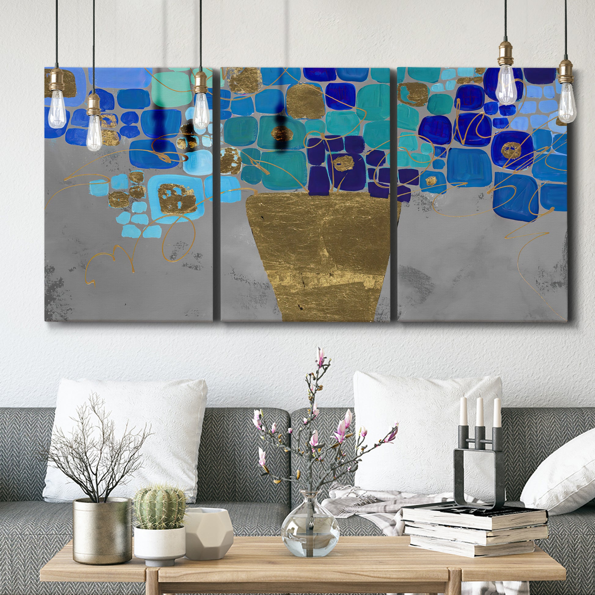Three-panel canvas wall art featuring blue floral abstract botanical expression, displayed in a modern living room above seating.