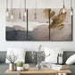 Three-panel canvas wall art featuring abstract watercolor with gold accents, displayed in a modern living room above seating.