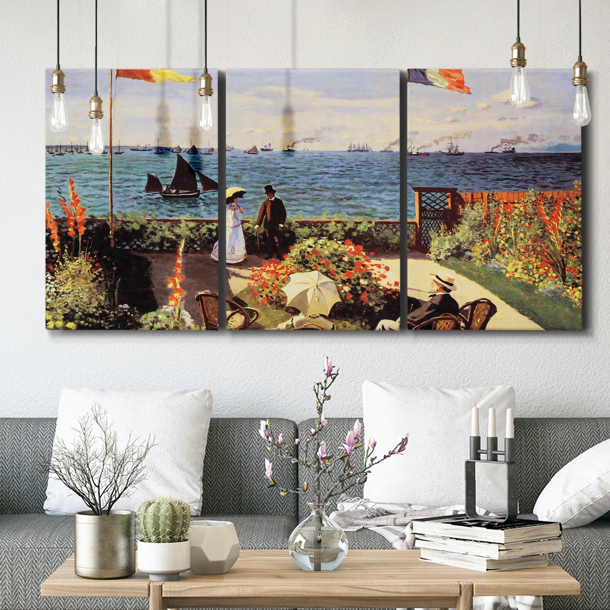 Three-panel canvas wall art featuring coastal garden overlooking sea, displayed in a modern living room above seating.