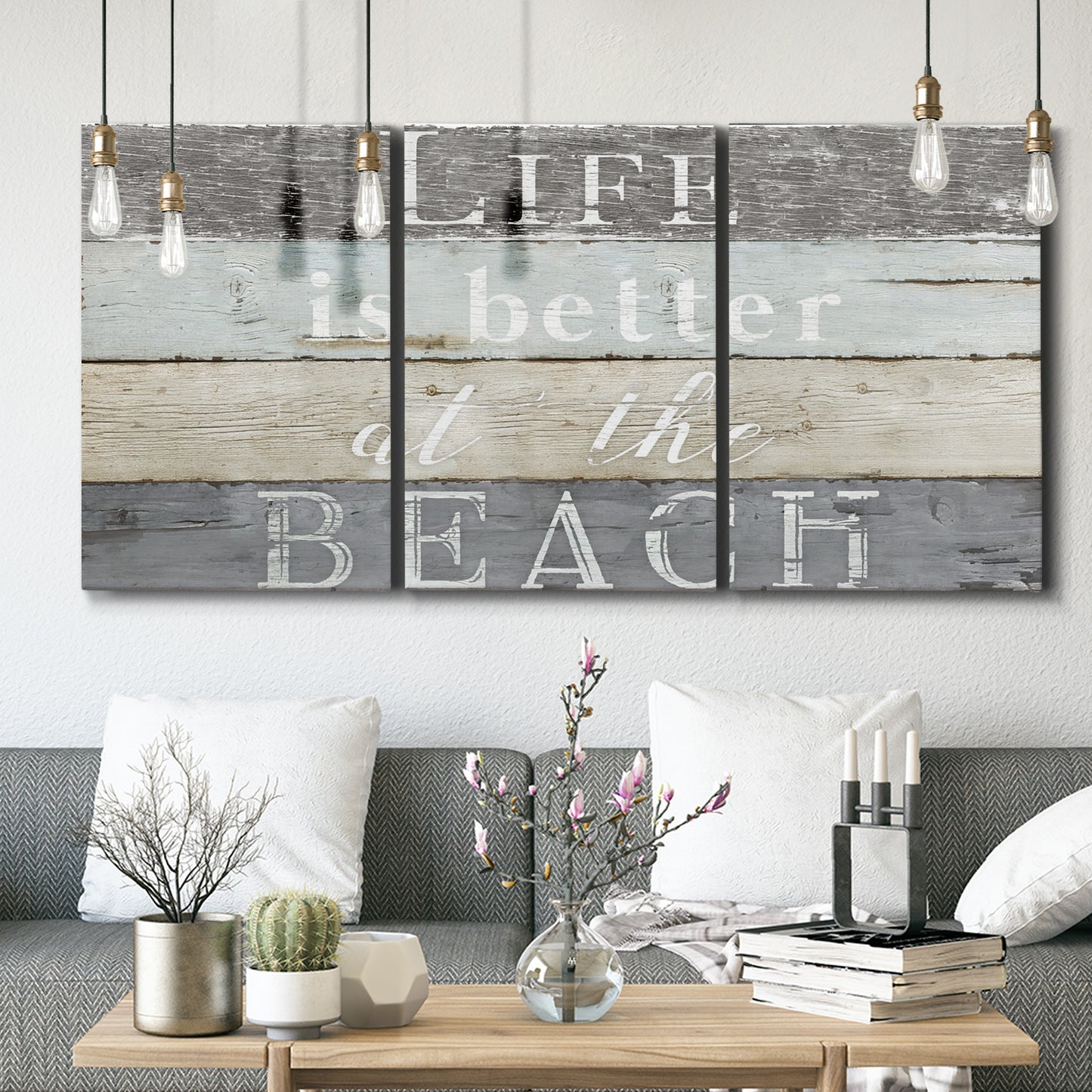 Three-panel canvas wall art featuring beach themed typography design, displayed in a modern living room above seating.
