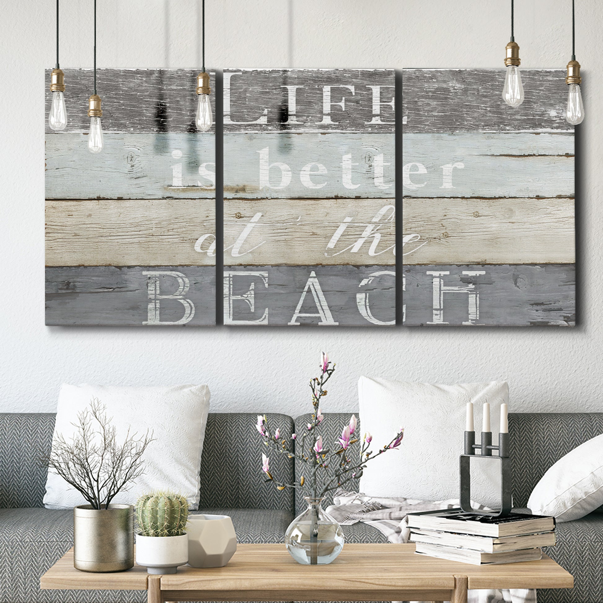 Three-panel canvas wall art featuring beach themed typography design, displayed in a modern living room above seating.