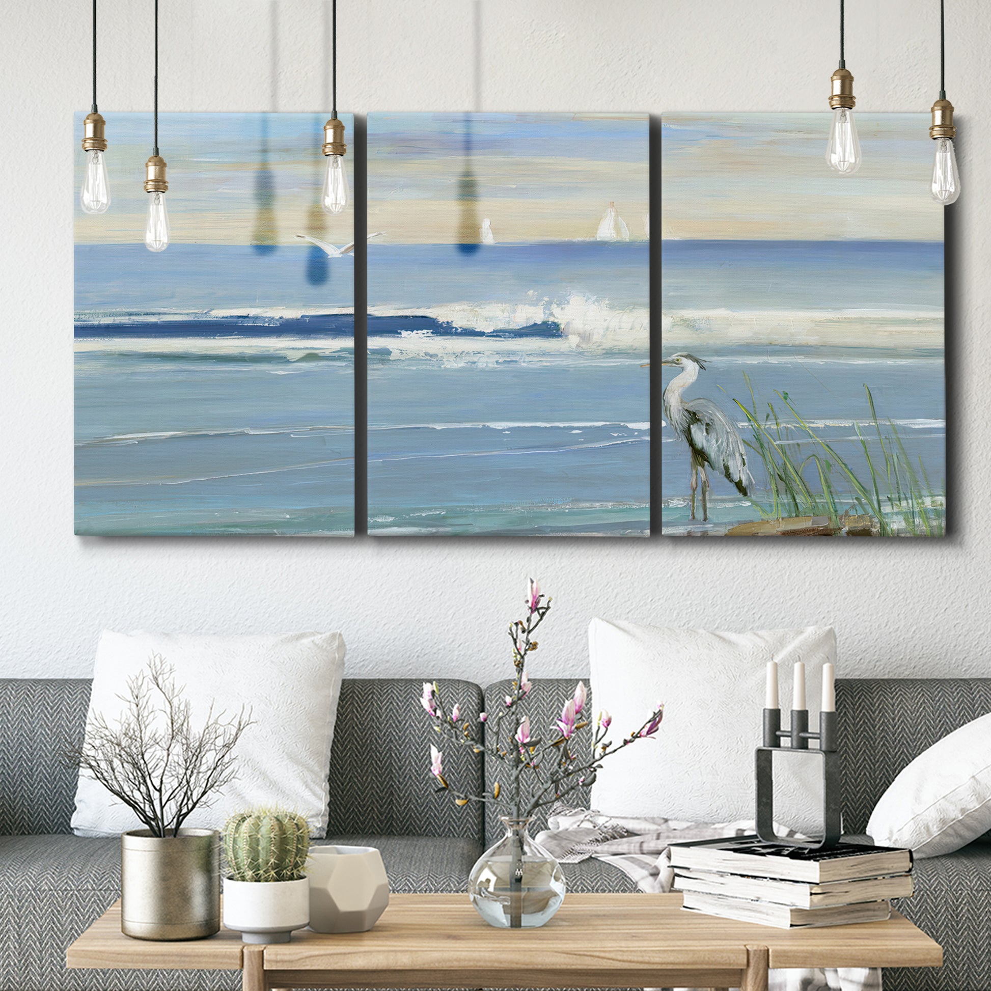 Three-panel canvas wall art featuring sunrise reflecting across bay waters, displayed in a modern living room above seating.