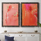 Set of two black barnwood framed canvas prints depicting a coordinated art pair of luminous coral orange and pink color fields with gold flecks rendered as glamorous fluid abstracts above a dining room sideboard.
