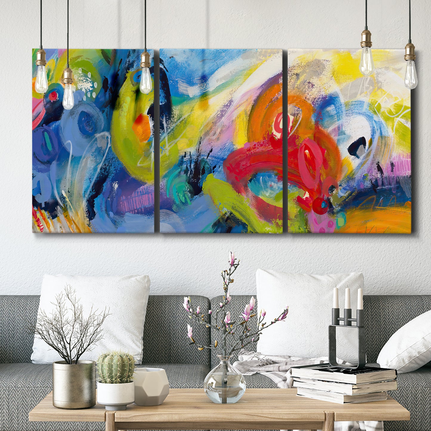 Three-panel canvas wall art featuring colorful abstract racing forms, displayed in a modern living room above seating.