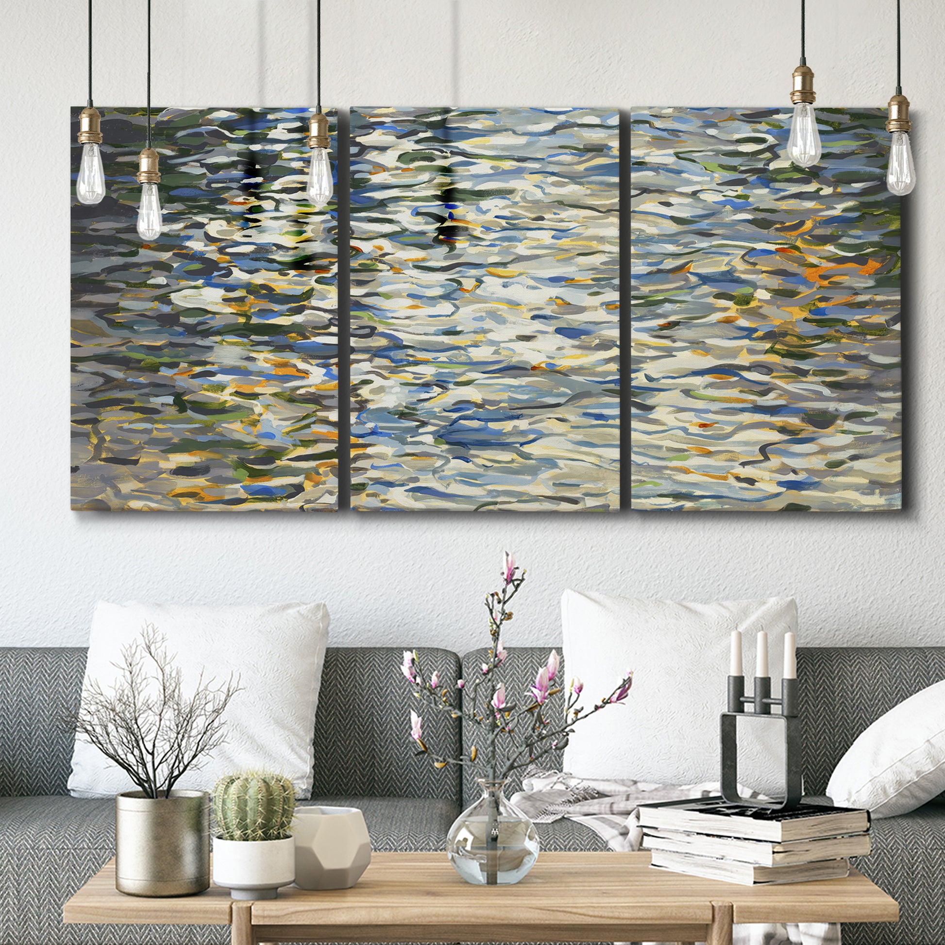 Three-panel canvas wall art featuring abstract water surface reflections, displayed in a modern living room above seating.
