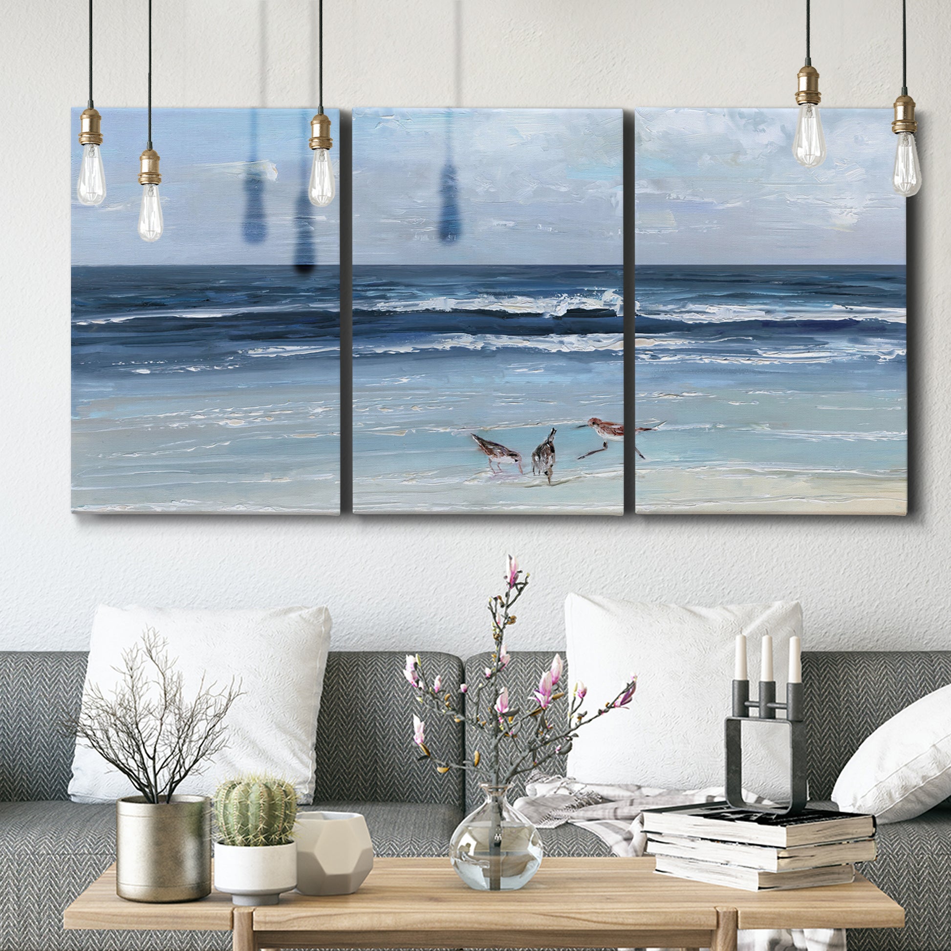 Three-panel canvas wall art featuring loose farmhouse style floral painting, displayed in a modern living room above seating.