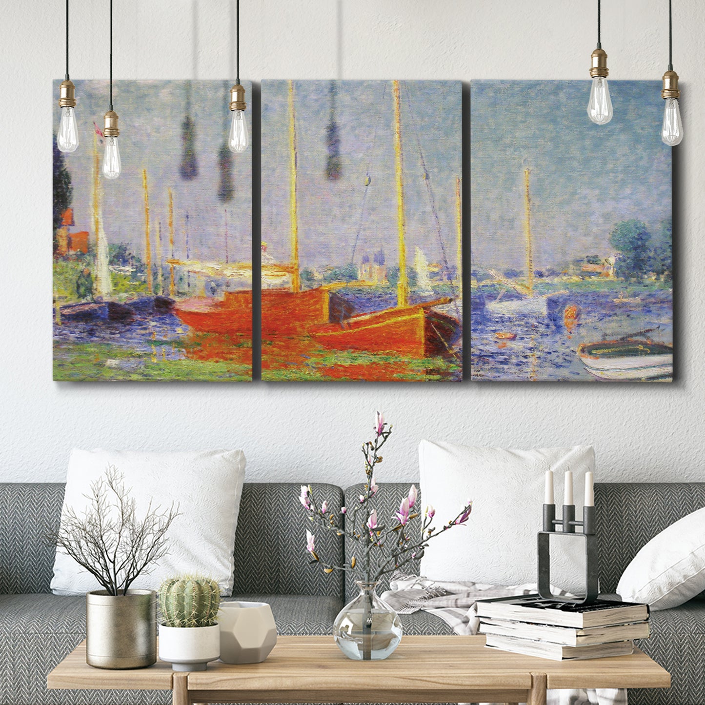 Three-panel canvas wall art featuring red boats along riverbank, displayed in a modern living room above seating.