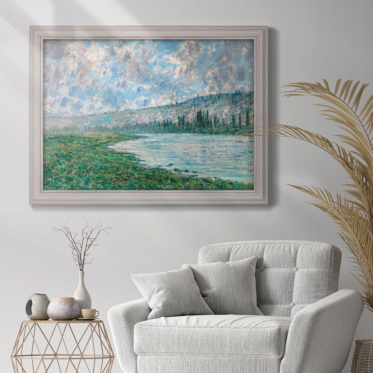 Impressionist river landscape at Vétheuil by Claude Monet in an ornate weathered white frame displayed in a bright interior setting.