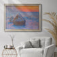 Impressionist haystack scene at sunset by Claude Monet in an ornate champagne frame displayed in a bright interior setting.