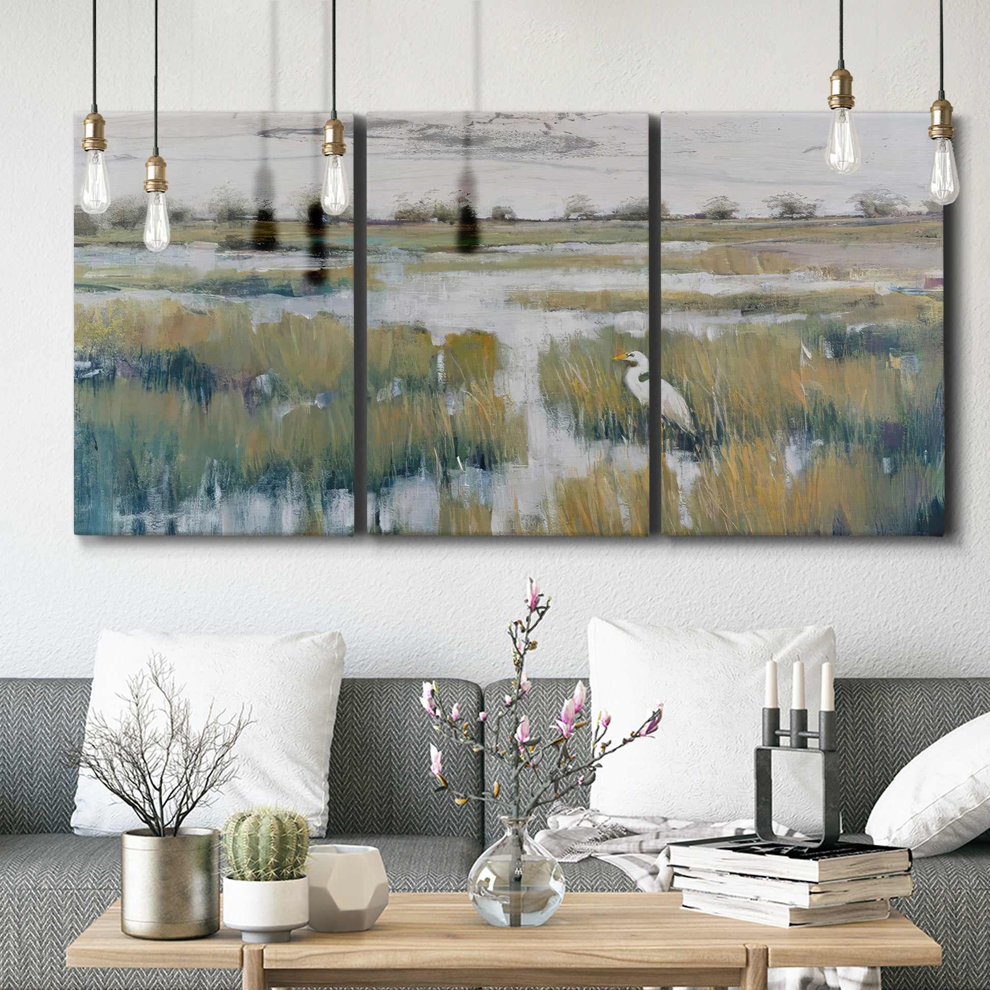 Three-panel canvas wall art featuring pastoral marshland landscape, displayed in a modern living room above seating.
