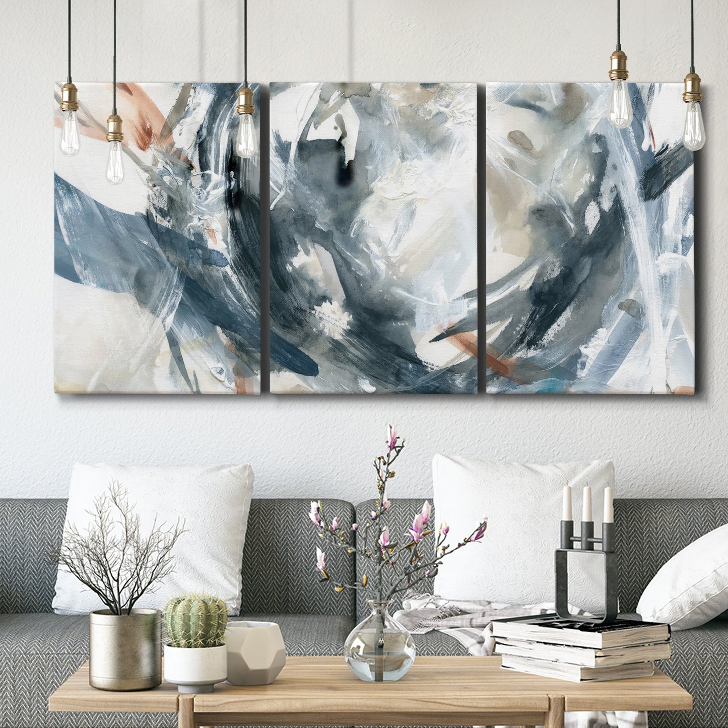 Three-panel canvas wall art featuring repeating abstract geometric array, displayed in a modern living room above seating.