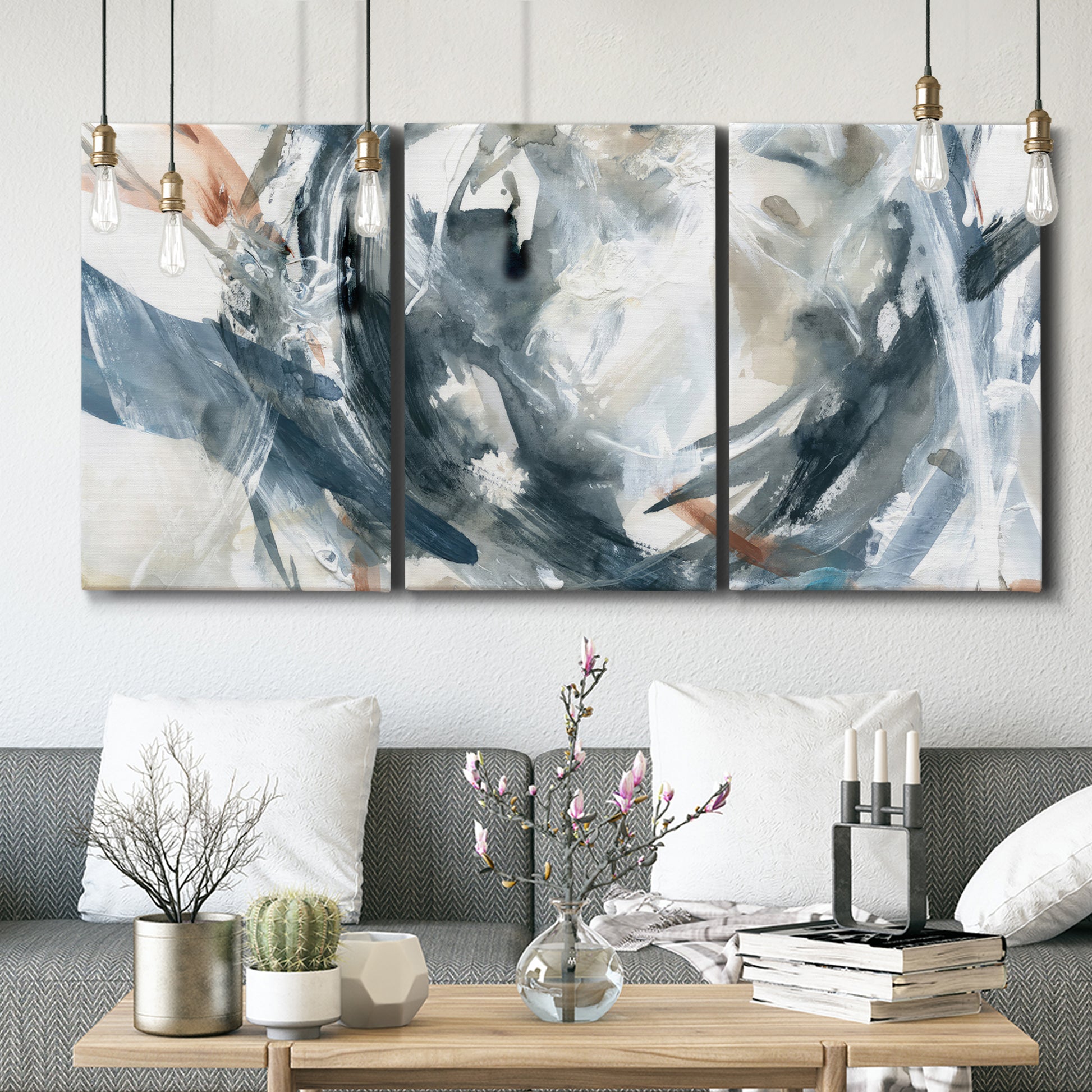 Three-panel canvas wall art featuring repeating abstract geometric array, displayed in a modern living room above seating.