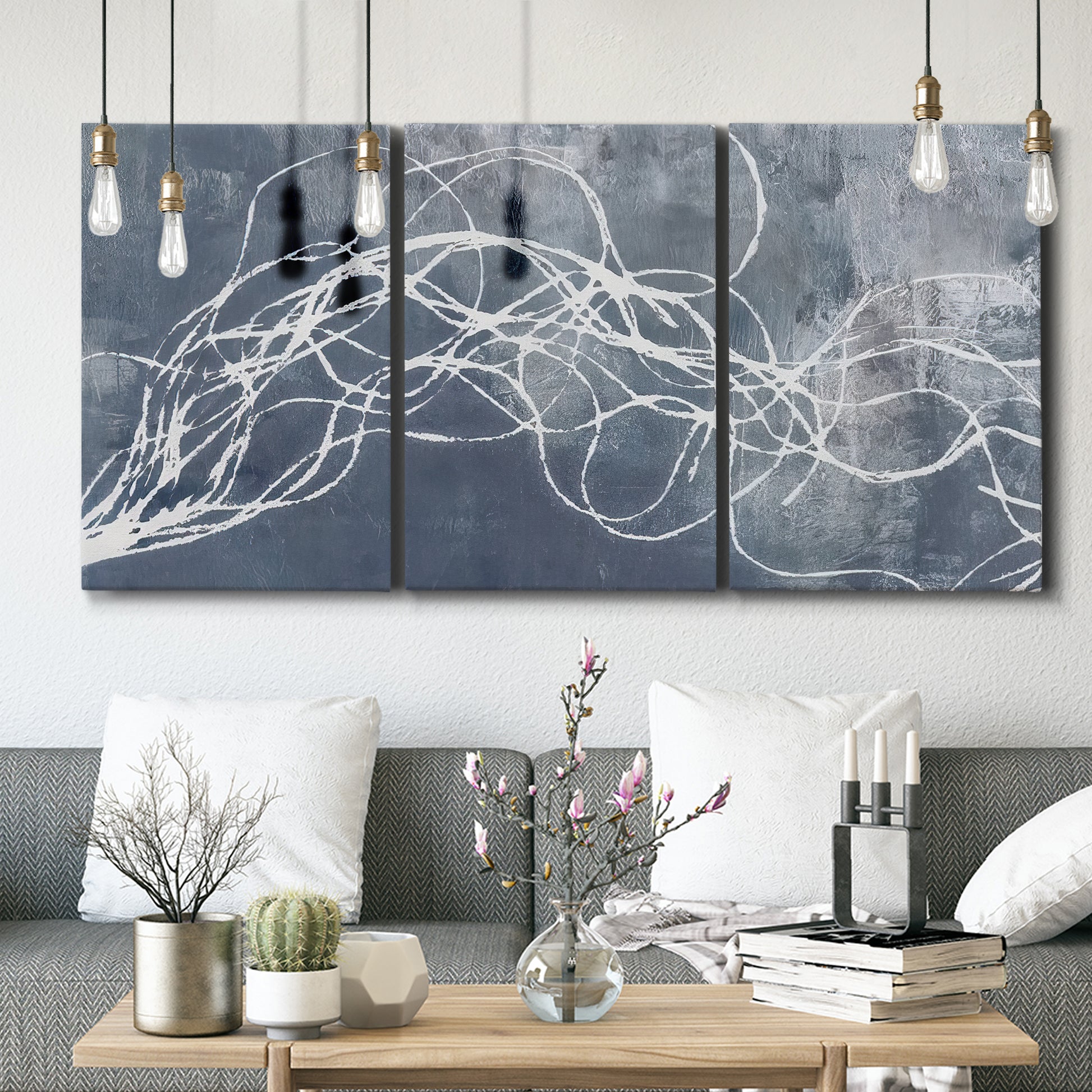 Three-panel canvas wall art featuring coastal shoreline at golden hour, displayed in a modern living room above seating.