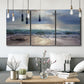 Three-panel canvas wall art featuring soft sunrise over open water, displayed in a modern living room above seating.