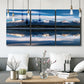 Three-panel canvas wall art featuring calm lake beneath mountains photograph, displayed in a modern living room above seating.