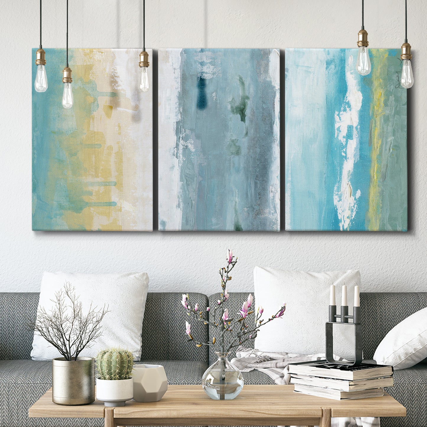 Three-panel canvas wall art featuring abstract coastal shoreline textures, displayed in a modern living room above seating.
