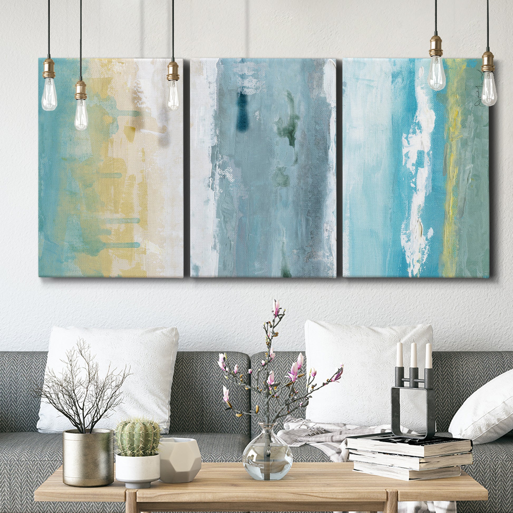 Three-panel canvas wall art featuring abstract coastal shoreline textures, displayed in a modern living room above seating.
