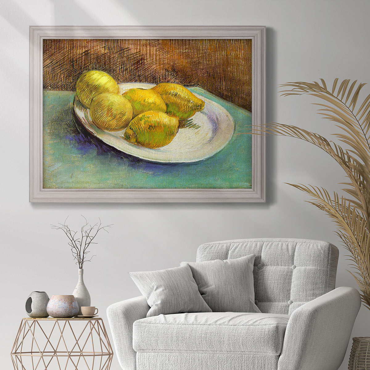 Impressionist still life with lemons by Vincent van Gogh in an ornate weathered white frame displayed in a bright interior setting.