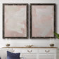 Set of two black barnwood framed canvas prints depicting a coordinated art pair of soft blush and white painterly fields rendered as minimalist color-field abstracts above a dining room sideboard.