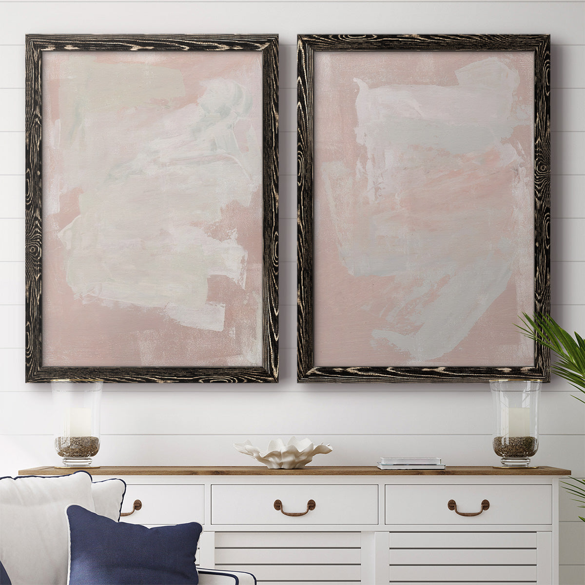 Set of two black barnwood framed canvas prints depicting a coordinated art pair of soft blush and white painterly fields rendered as minimalist color-field abstracts above a dining room sideboard.