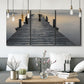 Three-panel canvas wall art featuring sunset over water photograph, displayed in a modern living room above seating.