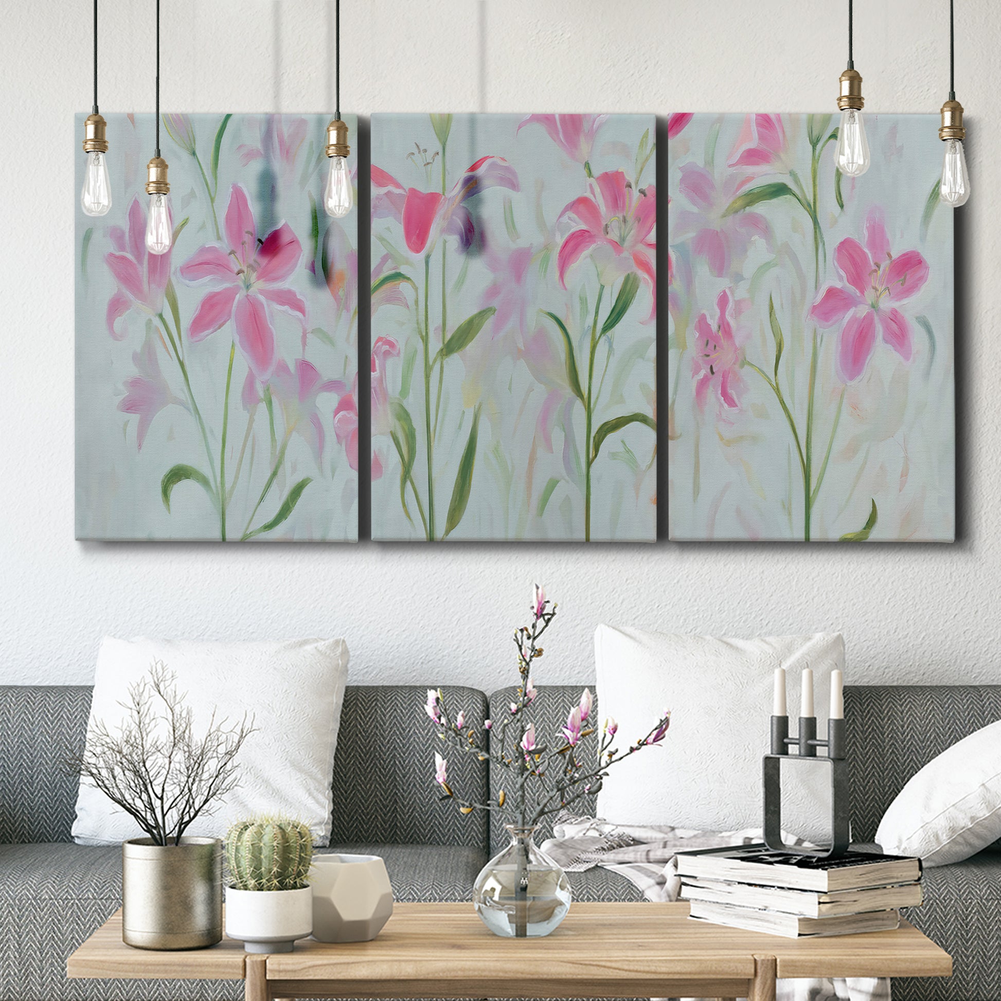 Three-panel canvas wall art featuring pink floral trio arrangement, displayed in a modern living room above seating.