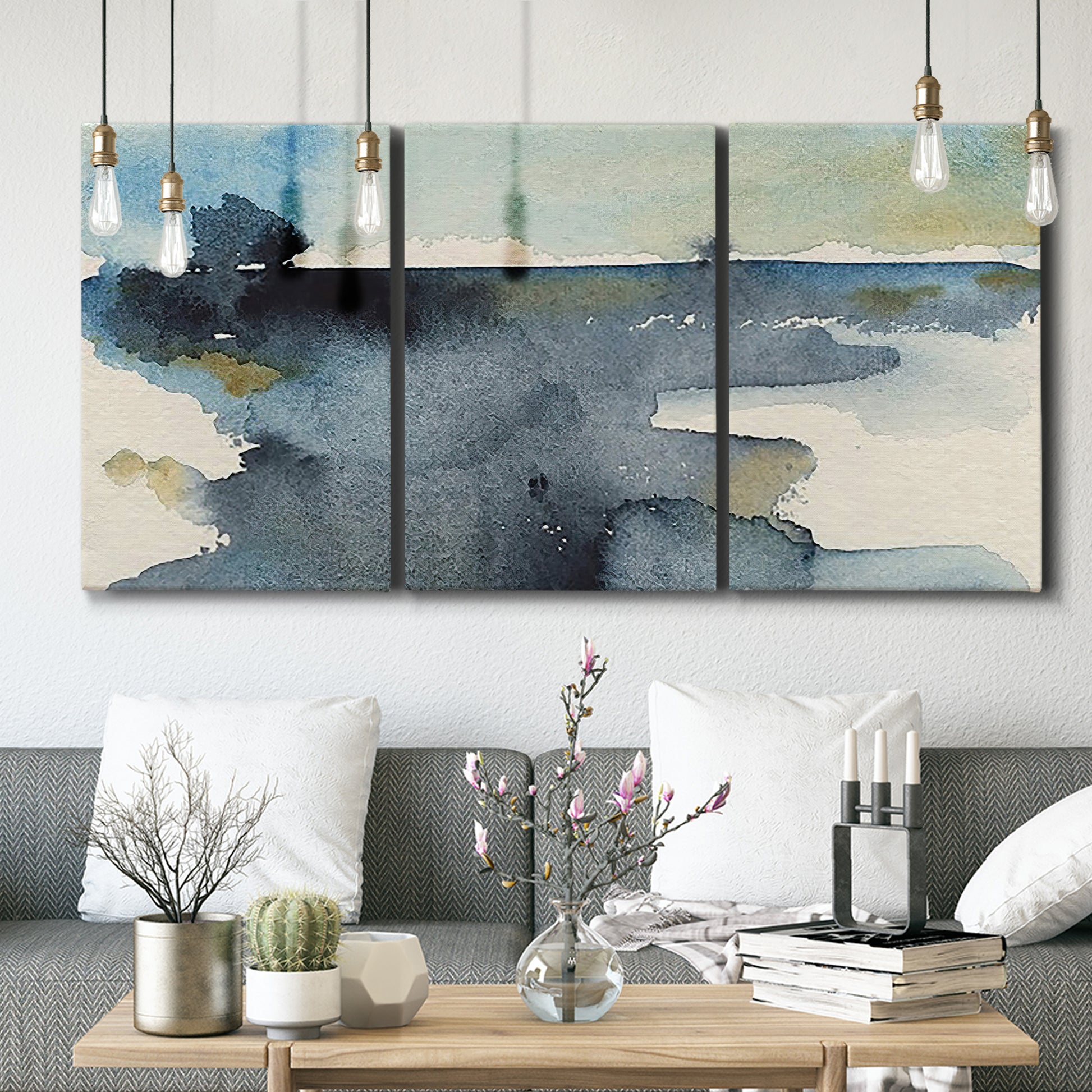 Three-panel canvas wall art featuring abstract watercolor with upward motion, displayed in a modern living room above seating.