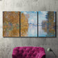 Three-panel canvas wall art featuring autumn landscape with glowing foliage, displayed in a living room above a suede accent chair.