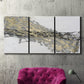 Three-panel canvas wall art featuring light modern abstract wind patterns, displayed in a living room above a suede accent chair.