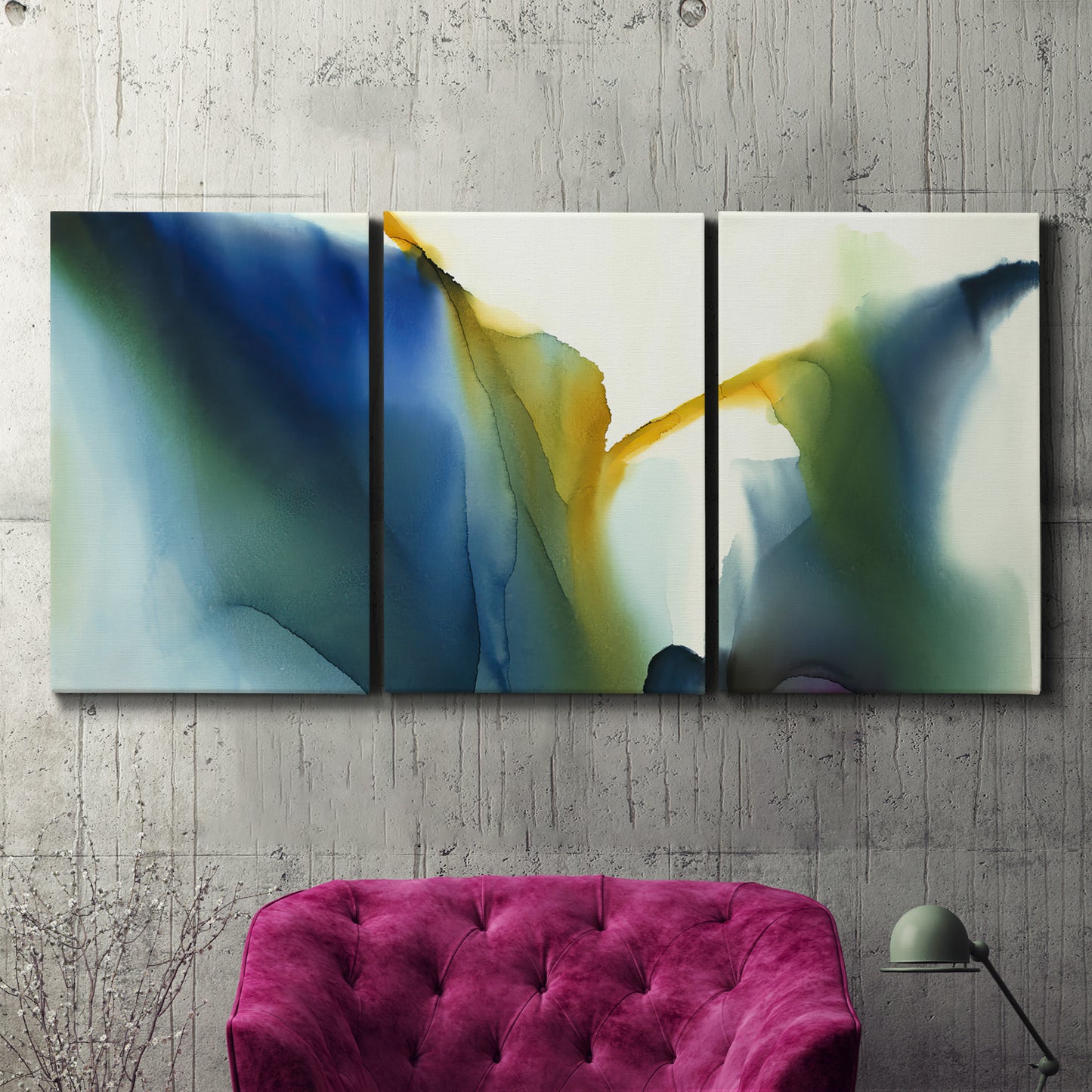 Three-panel canvas wall art featuring soft abstract mask like forms, displayed in a living room above a suede accent chair.