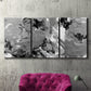 Three-panel canvas wall art featuring abstract marble texture composition, displayed in a living room above a suede accent chair.