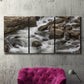 Three-panel canvas wall art featuring rushing river water over rocks, displayed in a living room above a suede accent chair.
