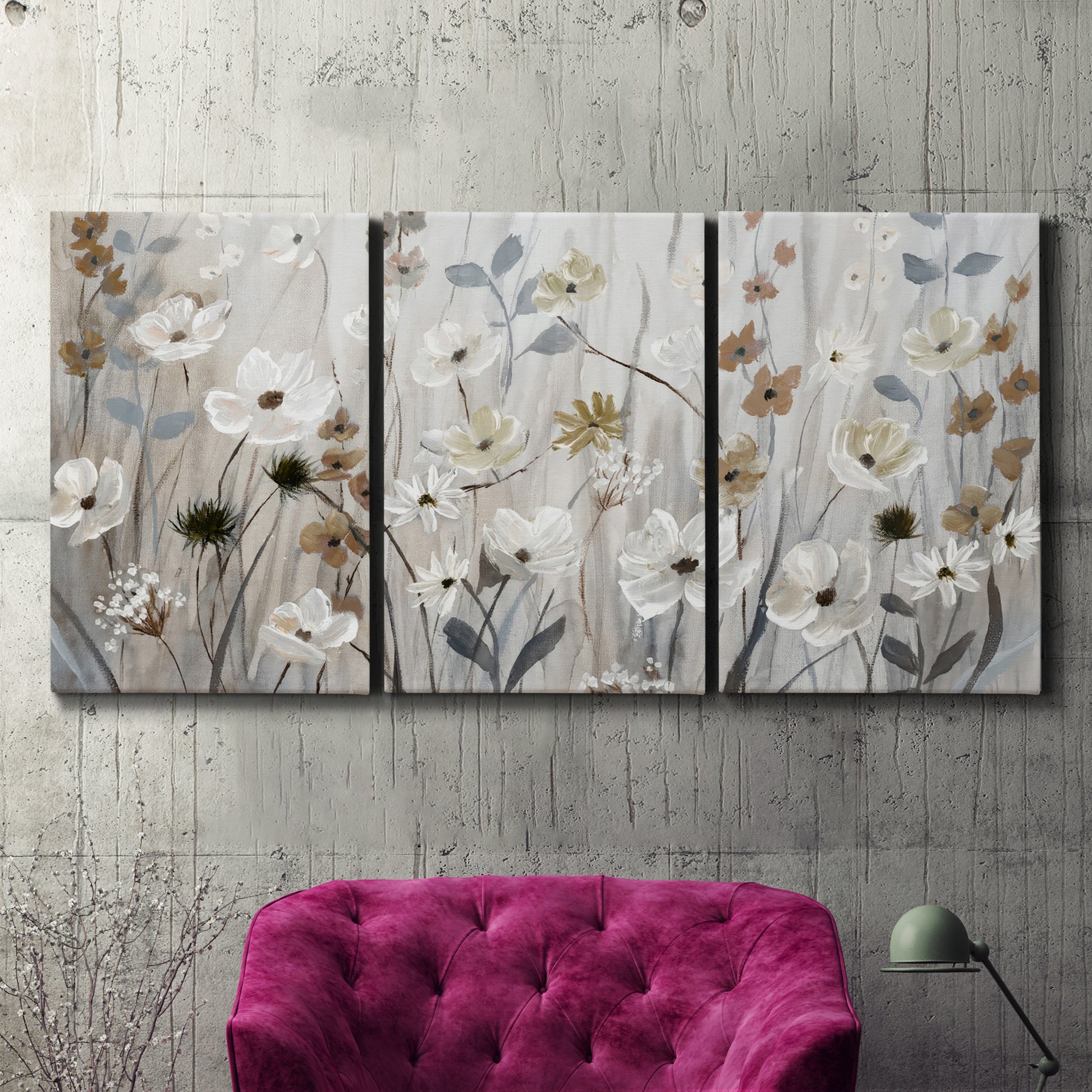 Three-panel canvas wall art featuring misty wildflower meadow landscape, displayed in a living room above a suede accent chair.