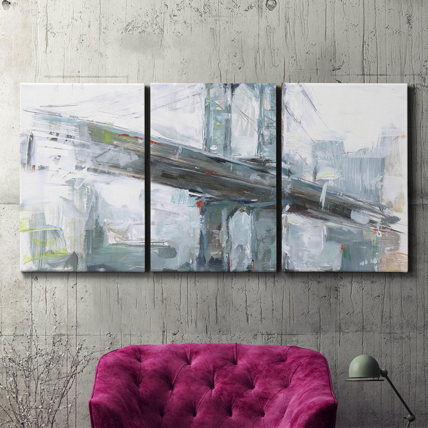 Three-panel canvas wall art featuring urban cityscape with architectural forms, displayed in a living room above a suede accent chair.