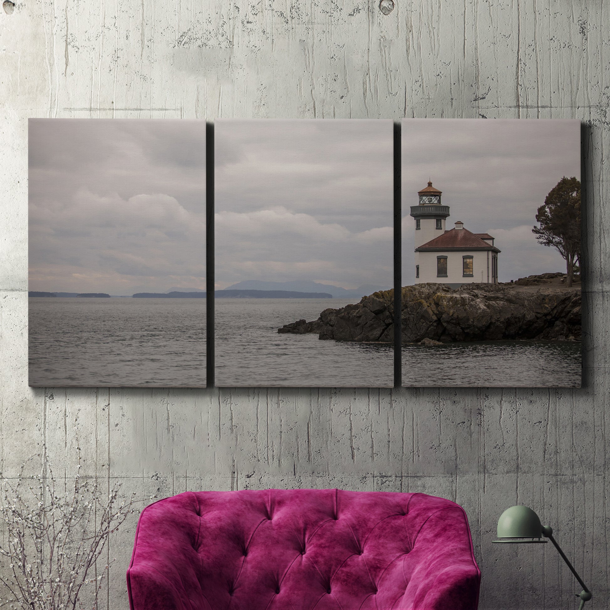 Three-panel canvas wall art featuring lighthouse watching over coastline, displayed in a living room above a suede accent chair.