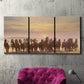 Three-panel canvas wall art featuring running horses captured in motion, displayed in a living room above a suede accent chair.