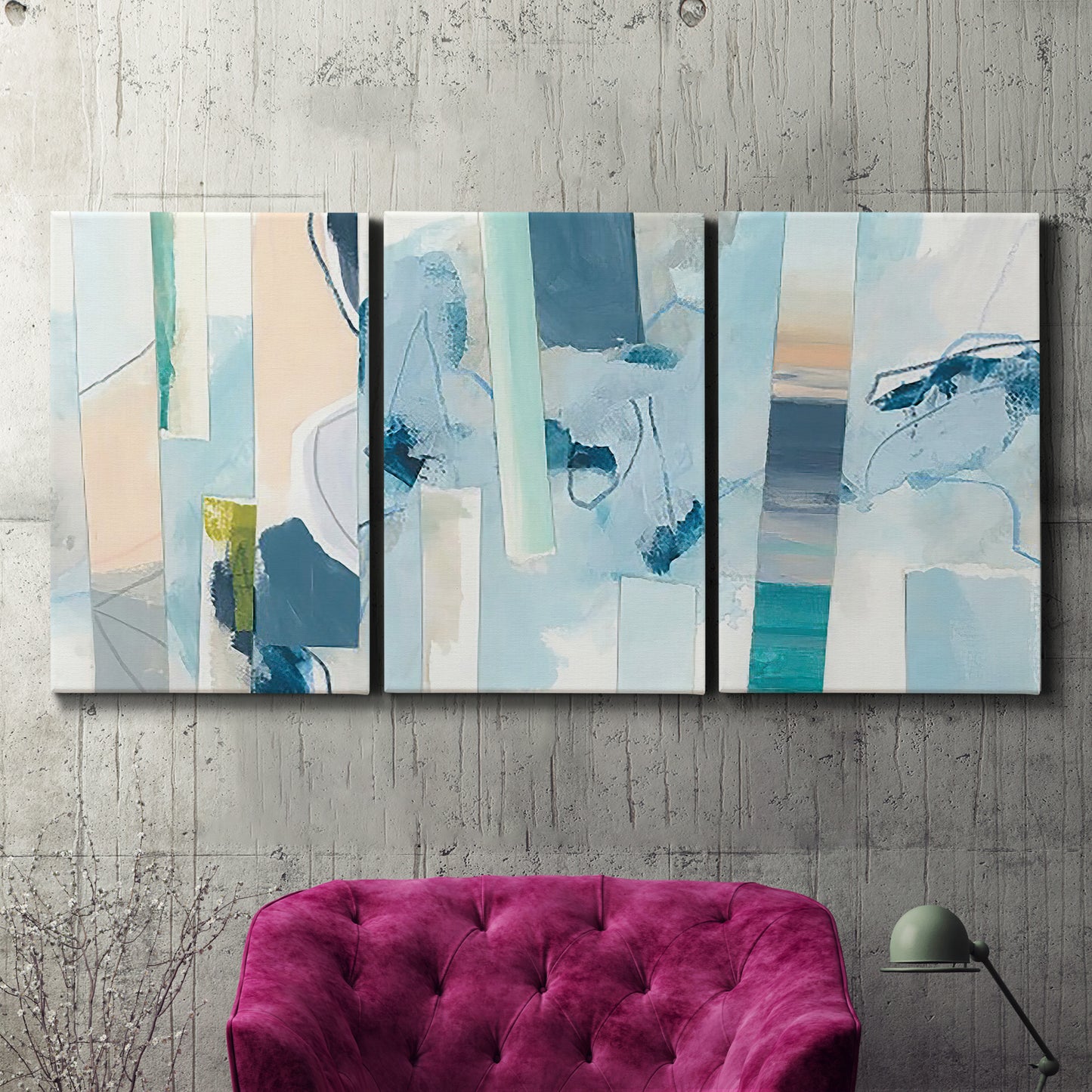 Three-panel canvas wall art featuring layered geometric abstract strata forms, displayed in a living room above a suede accent chair.