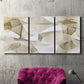 Three-panel canvas wall art featuring soft abstract meditative color balance, displayed in a living room above a suede accent chair.