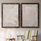 Set of two black barnwood framed canvas prints depicting two minimalist color-field abstracts featuring soft blush and white painterly fields above a sideboard in a cozy sitting room.