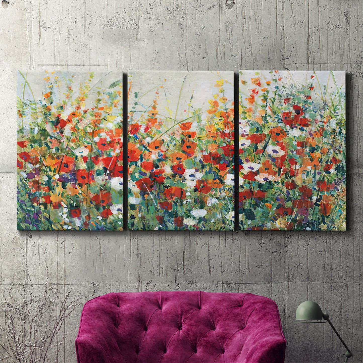 Three-panel canvas wall art featuring colorful garden flowers in bloom, displayed in a living room above a suede accent chair.
