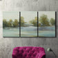 Three-panel canvas wall art featuring calming scenic landscape view, displayed in a living room above a suede accent chair.
