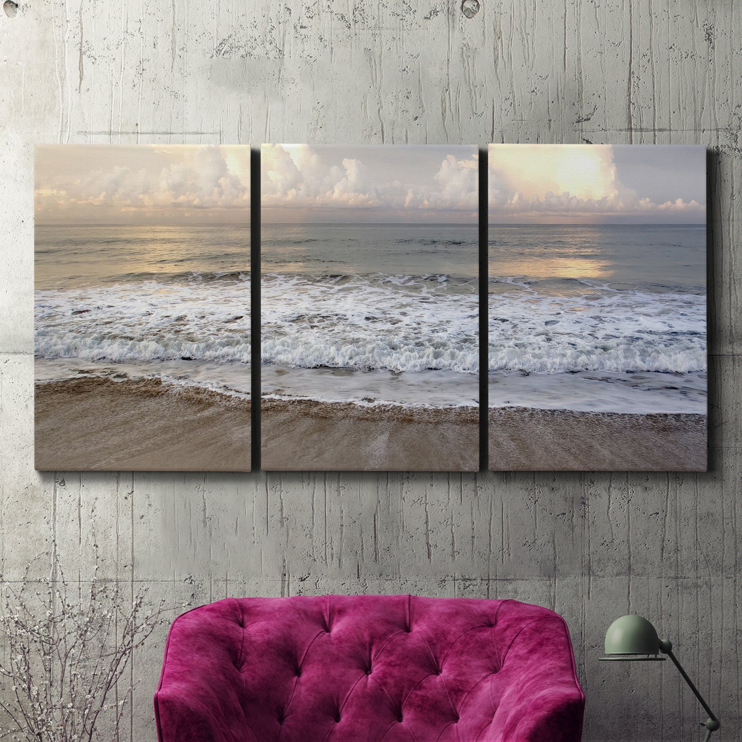 Three-panel canvas wall art featuring calm coastal shoreline seascape, displayed in a living room above a suede accent chair.