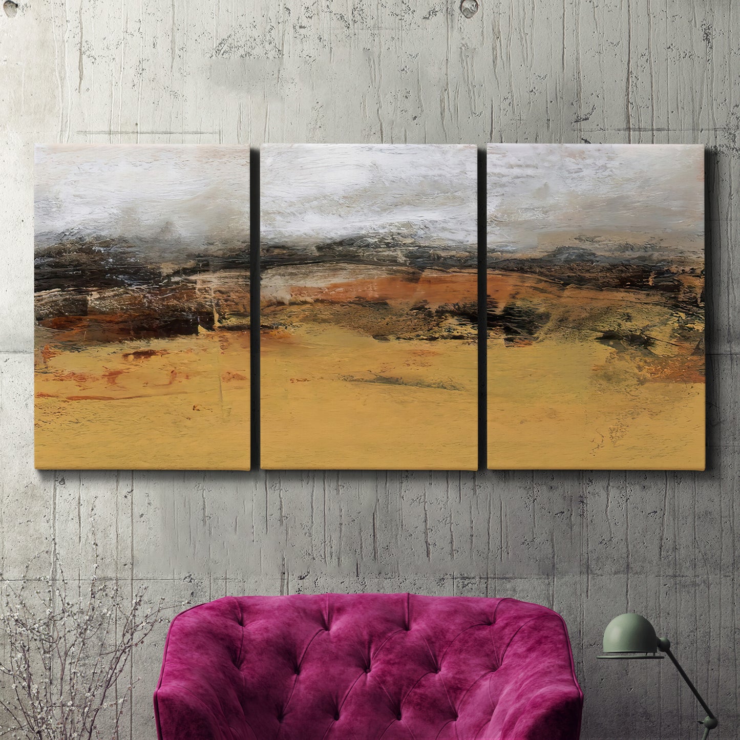 Three-panel canvas wall art featuring abstract bridge landscape in ochre, displayed in a living room above a suede accent chair.