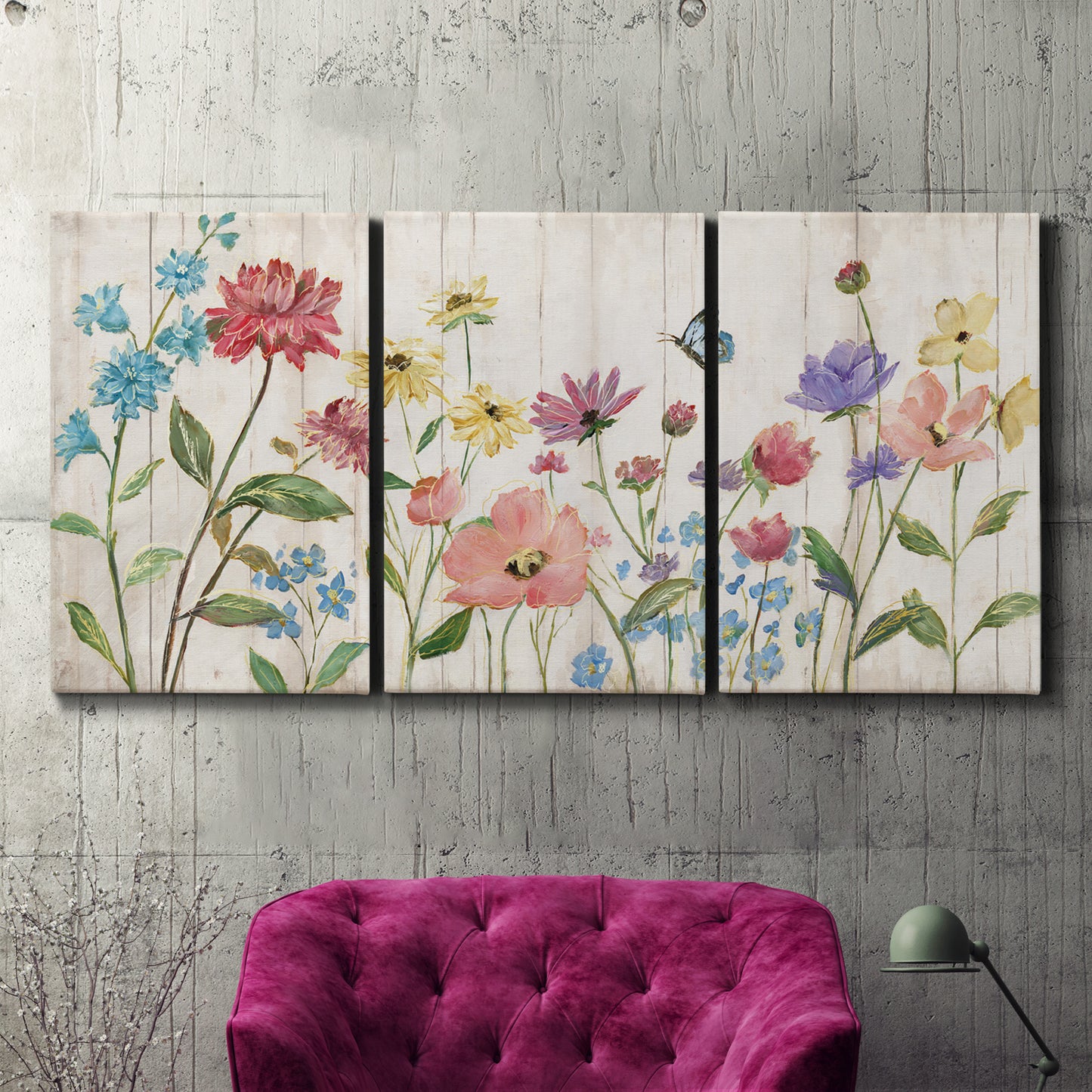 Three-panel canvas wall art featuring delicate wildflower illustration, displayed in a living room above a suede accent chair.