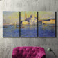 Three-panel canvas wall art featuring layered modern abstract color ribbons, displayed in a living room above a suede accent chair.